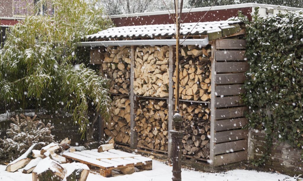 Logs in a wood store on a snowy day